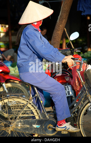 Vietnamesin in charakteristischen konischen Hut auf Fahrrad, Bac Ha, Lao Cai Provine, Vietnam Stockfoto