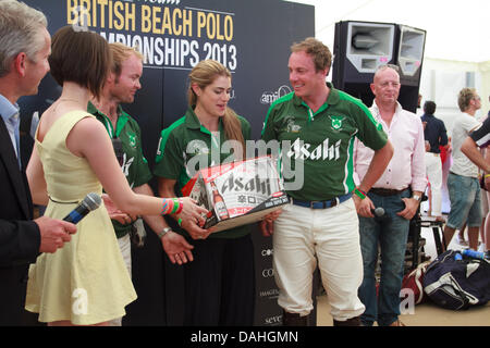 Sandbänke, Poole, Dorset, UK 13. Juli 2013: irische Polo Team erhält eine Schachtel mit Asahi Beer Stockfoto