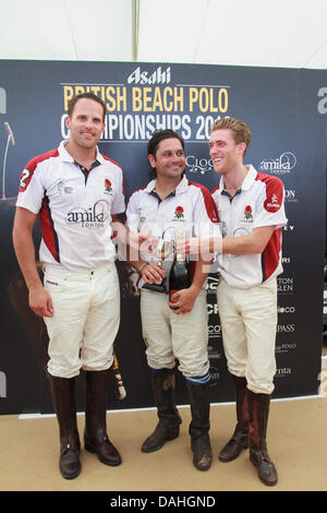 Sandbänke, Poole, Dorset, UK 13. Juli 2013: England-Team erhält die Trophyas der Gewinner des Asahi British Beach Polo Championship 2013 Stockfoto