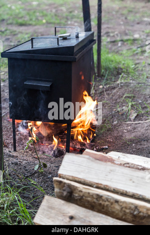 mobiles Lager Räucherei warm auf Brennholz und Feuer Stockfoto