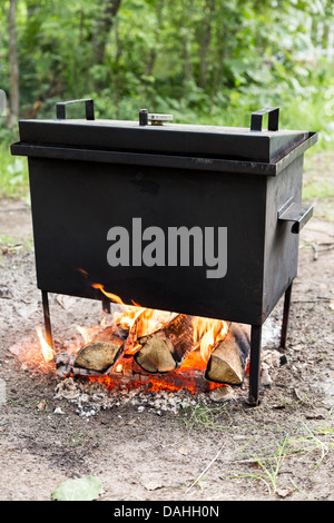 mobiles Lager Räucherei warm auf Brennholz und Feuer Stockfoto