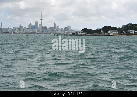 Auckland-Innenstadt (CBD) von Torpedo Bay, Devonport mit rauer See im Vordergrund Stockfoto