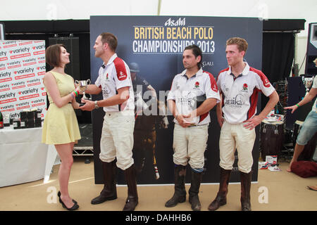 Sandbänke, Poole, Dorset, UK 13. Juli 2013: England-Team erhält den Pokal als Sieger des Asahi British Beach Polo Championship 2013 Stockfoto