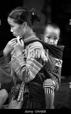 Schwarz / weiß Bild der Flower Hmong Frau im unverwechselbaren Stammes-Kleid mit Kind, Coc Ly. Lao Cai Provinz, Vietnam Stockfoto