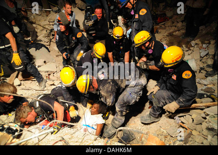 Mitglieder des Los Angeles County Fire Department Search and Rescue Team retten eine haitianische Frau aus einem eingestürzten Gebäude im Anschluss an ein Erdbeben der Stärke 7,0, die 220.000 Menschen 17. Januar 2010 in Port-au-Prince, Haiti getötet. Die Frau überlebt 5 Tage ohne Nahrung oder Wasser in den Trümmern. Stockfoto