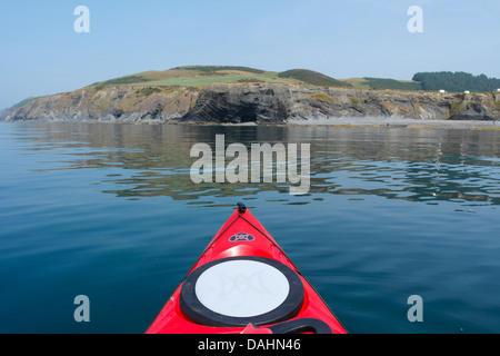 Bogen des roten Kajak zeigt in Richtung einer Meereshöhle in den Klippen am Clarach, in der Nähe von Aberystwyth, Cardigan Bay Stockfoto