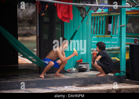 Vietnamesische Teenange Freunde und Brüder auf ihrem schwimmenden Zuhause, Halong Bucht, Vietnam Stockfoto