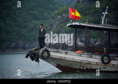 Vietnamesische Mann stand auf einem Boot, Halong Bucht, Vietnam Stockfoto