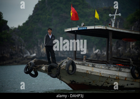 Vietnamesische Mann stand auf einem Boot, Halong Bucht, Vietnam Stockfoto