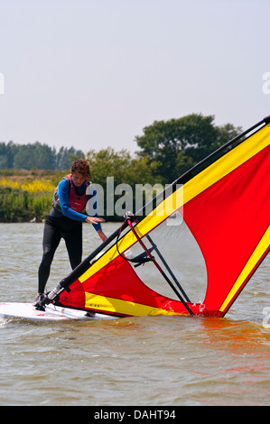 Mittlere gealterte Frau lernen, Windsurf UK Windsurfer Windsurfen Stockfoto