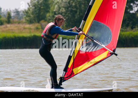 Mittlere gealterte Frau lernen, Windsurf UK Windsurfer Windsurfen Stockfoto