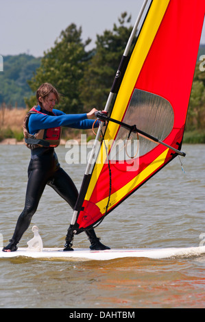 Mittlere gealterte Frau lernen, Windsurf UK Windsurfer Windsurfen Stockfoto