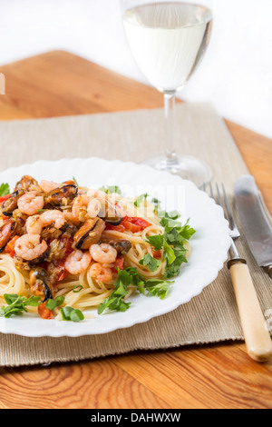 Pasta mit Meeresfrüchten und Weißwein auf Servietten Stockfoto