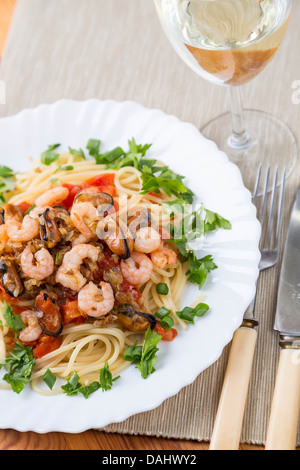 Pasta mit Meeresfrüchten und Weißwein auf Servietten Stockfoto