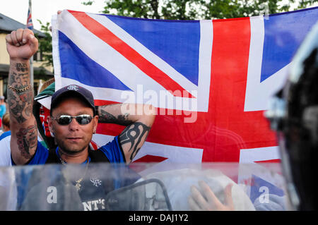 Belfast, Nordirland, 14. Juli 2013 - ein Demonstrant Loyalist gibt einen trotzigen Gruß neben einer Union Flag-Credit: Stephen Barnes/Alamy Live News Stockfoto