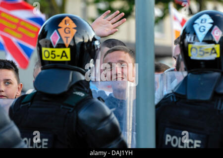 Belfast, Nordirland, 14. Juli 2013 - ein Demonstrant Loyalist winkt und lächelt von hinten Polizei-Linien. Bildnachweis: Stephen Barnes/Alamy Live-Nachrichten Stockfoto