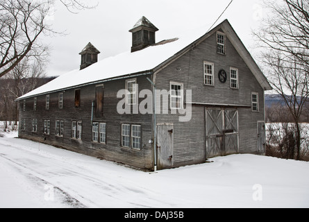 Alte, graue Holzscheune mit Weihnachtskranz und Winterschneelandschaft auf einem Bauernhof in Vermont, Farm, New England, VT US Christmas Farm Scene Stockfoto