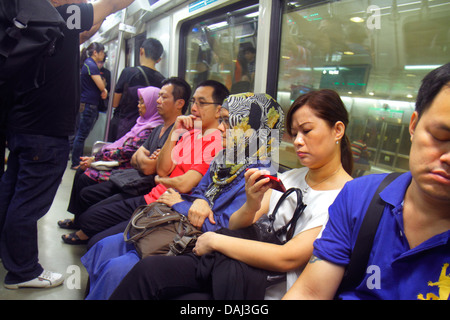 Singapur, Bugis MRT-Station, East West Line, U-Bahn-Zug, Fahrer, Pendler, asiatischer Mann, Männer, Frau, Frauen, Blick auf, Smartphone, Telefone, überprüfen Stockfoto