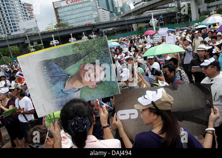 Bangkok, Thailand. 14. Juli 2013. Mitglied des weißen Masken Demonstrant hält ein Porträt von Thailands König Bhumibol Adulyadej während einer Protestaktion im Lumpini-Park. Guy Fawkes weiße Masken Gruppe weiter Protest in Bangkok und in Provinzen in Thailand gegen die Regierung von Yingluck Shinawatra. Bildnachweis: Piti A Sahakorn/Alamy Live-Nachrichten Stockfoto