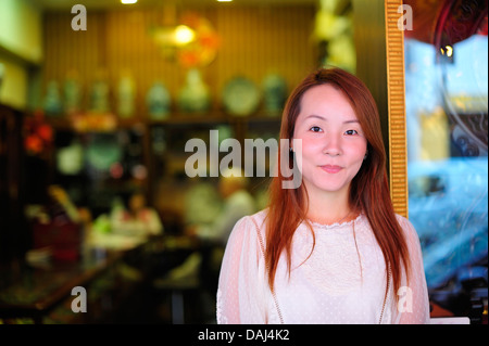 Chinesisches Mädchen in ihrem Unternehmen in Singapur Stockfoto