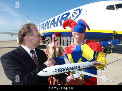 Vorsitzender der Irland ansässige Fluggesellschaft Ryanair, Michael O'Leary (L), stellt zusammen mit einem Schauspieler verkleidet in ein Brocken Wich Trachten- und der Minister für Wirtschaft des Landes Sachsen-Anhalt, Reiner Haseloff (CDU, R), nach seiner Ankunft am Flughafen Magdeburg Cochstedt International in Cochstedt, Deutschland, 23. März 2011. Ryanair startet am 30. März 2011 mit zwei we Stockfoto