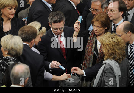 Deutsche Innenminister Defence Thomas de Maiziere (C) wirft seinen Stimmzettel, wie der Deutsche Bundestag über die NATO Awacs-Einsatz in Berlin, Deutschland, 25. März 2011 entscheidet. Deutschen Bundestages genehmigt den Einsatz von Awacs-Flugzeugen in der NATO-Mission zur Polizei Libyen Flugverbotszone. Foto: HANNIBAL Stockfoto