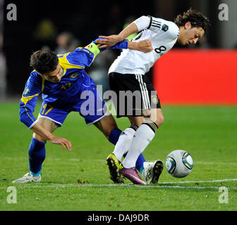 Deutschen Mesut Özil (R) wetteifert um den Ball mit Kairat Nurdauletov von Kasachstan während der UEFA Euro 2012 Qualifikation Gruppe A Fussball Match zwischen Deutschland und Kasachstan in die Fritz-Walter-Stadion in Kaiserslautern, Deutschland, 26. März 2011. Foto: Dpa/Lrs Marius Becker Stockfoto