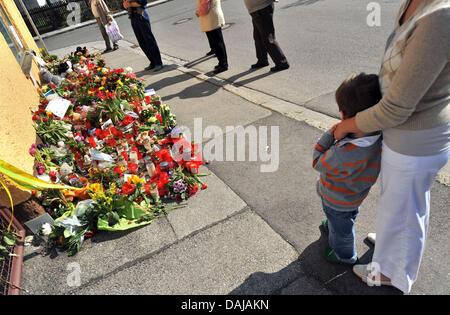 Menschen stehen in der Nähe von Blumen, Kerzen und Teddybären befindet sich vor einem Haus, wo zwei Mädchen am 24. März 2011 in Krailling, Deutschland, 29. März 2011 ermordet wurden. Die Trauerfeier für die beiden Schwestern Chiara (8) und Sharon (11) findet am Abend des 29. März 2011. Foto: Andreas Gebert Stockfoto