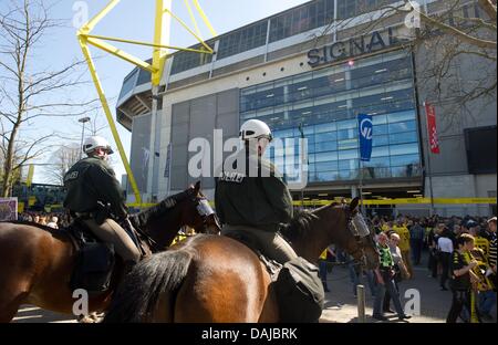 Berittene Polizisten überwachen die Menschenmenge vor dem Stadion, bevor die deutsche Bundesliga Borussia Dortmund vs. Hannover 96 im Signal Iduna Park in Dortmund, Deutschland, 2. April 2011 entsprechen. Foto: ROLAND WEIHRAUCH Stockfoto