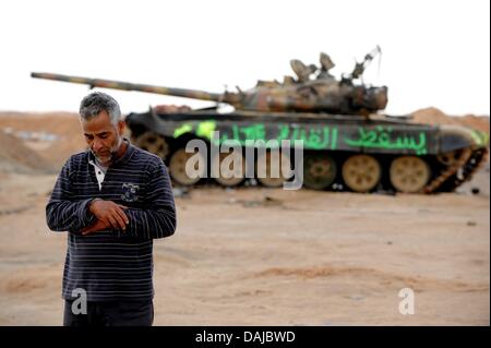 Die libyschen Aufständischen Muftah El Shahomi betet vor ein zerstörter Panzer in Ajdabiya, Libyen. Muammar Al-Gaddafi hat ein Rebell vorgeschlagenen Waffenstillstand abgelehnt. Foto: MAURIZIO GAMBARINI Stockfoto