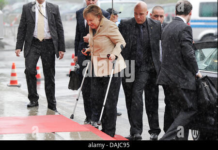 Nach Knie-OP am 1. April 2011 unterzogen, kommt die deutsche Bundeskanzlerin Angela Merkel auf Krücken zur Eröffnung der Hannovermesse in Hannover, 3. April 2011. Die Hannovermesse ist die größte Industriemesse der Welt und beherbergt mehr als 6,500 Aussteller aus 65 Ländern ab 04 bis 08 April. Foto: JULIAN STRATENSCHULTE Stockfoto