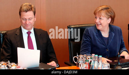 Bundeskanzlerin Angela Merkel eröffnet der Kabinettssitzung im Kanzleramt in Berlin, 6. April 2011. Außenminister Westerwelle studiert seine Dokumente. FOTO: WOLFGANG KUMM Stockfoto