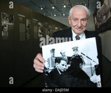 Israelischer Rechtsanwalt und ehemalige stellvertretende Staatsanwalt in der Hauptverhandlung gegen Nazi-kriminellen Adolf Eichmann, Gabriel Bach, hält ein Foto in der Hand die Birkenauer und ihn während der Verhandlung, in der Ausstellung zeigt "mit Blick auf Gerechtigkeit - Adolf Eichmann vor Gericht (Der Prozess - Adolf Eichmann Vor Gericht) in Berlin, Deutschland, 5. April 2011. Die Ausstellung, die den Prozess gegen Birkenauer in 196 dokumentiert Stockfoto