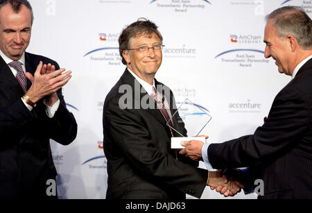 Microsoft-Gründer Bill Gates (C) schüttelt Hände Fred Irwin (R), der Präsident der amerikanischen Handelskammer in Deutschland und US-Botschafter Philip Murphy (L), wie er die Transatlantic Partnership Award in Berlin, Deutschland, 6. April 2011 erhält. Gates erhielt die Auszeichnung für seine sozialen Engagements. Foto: Michael Kappeler Stockfoto