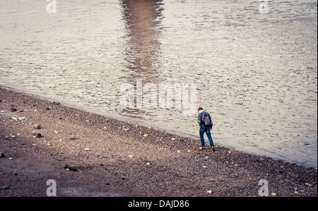 Ein Mann zu Fuß entlang des südlichen Ufers des Flusses Themse in London Stockfoto