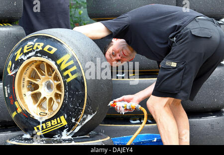 Ein Mechaniker von Renault Lotus sauber racing Reifen nach dem dritten Training auf dem Sepang Circuit außerhalb Kuala Lumpur, Malaysia, 9. April 2011. Der Formel 1 Grand Prix von Malaysia stattfinden am 10. April 2011. Foto: Jens Buettner dpa Stockfoto