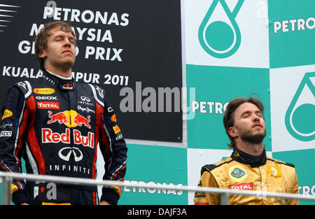 Deutsche Formel1-Fahrer Sebastian Vettel (L) von Red Bull Racing und deutsche Formel1-Fahrer Nick Heidfeld von Lotus Renault auf dem Podium nach dem Gewinn der Formel 1 Grand Prix von Malaysia auf dem Sepang Circuit außerhalb Kuala Lumpur, Malaysia, 10. April 2011 zu feiern. Foto: Jens Buettner dpa Stockfoto