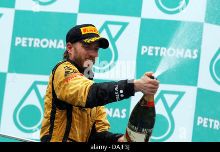 Deutsche Formel1-Fahrer Nick Heidfeld von Lotus Renault feiert nach dem dritten Platz in der Formel 1 Grand Prix von Malaysia auf dem Sepang Circuit außerhalb Kuala Lumpur, Malaysia, 10. April 2011 zu machen. Foto: Jens Büttner Stockfoto