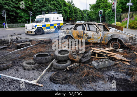 Belfast, Nordirland. 15. Juli 2013 - lenkt ein Polizei Landrover Verkehr weg von Schutt, die nach einer Nacht der Krawalle in Belfast Stockfoto