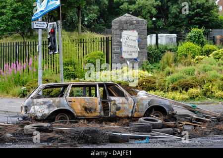 Belfast, Nordirland. 15. Juli 2013 - ausgebrannt A Auto blockiert die Straße in Mount Vernon nach einer Nacht der Ausschreitungen Stockfoto