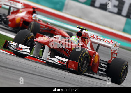 Brasilianischer Formel-1-Pilot Felipe Massa Ferrari steuert sein Auto durch eine Kurve vor spanischen Formel-1-Fahrer Fernando Alonso Ferrari nach dem Start der Formel 1 Grand Prix von Malaysia auf dem Sepang Circuit außerhalb Kuala Lumpur, Malaysia, 10. April 2011. Foto: Jens Buettner dpa Stockfoto