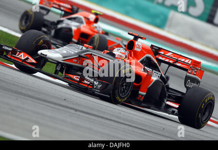 Deutsche Formel1-Fahrer Timo Glock der Jungfrau steuert sein Auto durch eine Kurve vor belgischen Formel1 Fahrer Jerome D'Ambrosio der Jungfrau nach dem Start der Formel 1 Grand Prix von Malaysia auf dem Sepang Circuit außerhalb Kuala Lumpur, Malaysia, 10. April 2011. Foto: Jens Buettner dpa Stockfoto