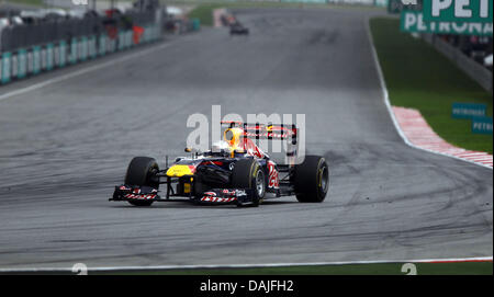 Deutsche Formel1-Fahrer Sebastian Vettel von Red Bull steuert sein Auto durch eine Kurve nach dem Start der Formel 1 Grand Prix von Malaysia auf dem Sepang Circuit außerhalb Kuala Lumpur, Malaysia, 10. April 2011. Foto: Jens Buettner dpa Stockfoto