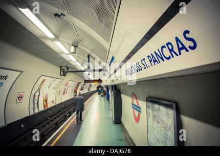 Ein Mann geht auf dem Bahnsteig an u-Bahnstation Kings Cross St. Pancras in London, Vereinigtes Königreich Stockfoto