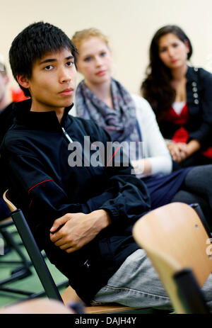 Andreas Wolff (vorne) sitzt mit seinen Klassenkameraden in einem Klassenzimmer in der Kaiserin-Theophanu-Schule in Köln, Deutschland, 11. April 2011. Einen Monat nach dem Beginn der Erdbebenkatastrophe in Japan, beginnt das Jahr für die deutsche Schule in der Nähe von Tokio, nicht in Japan sondern Köln. 35 Jugendliche "Asyl" in einer High-School-Iin Köln gefunden haben und sind dort von ihrem Lehrer aus th gelehrt Stockfoto