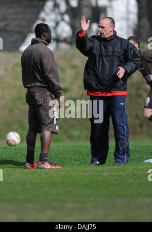 Coach Holger Stanislawski (R) spricht Stürmer Gerald Asamoah im Trainingsgelände in Hamburg, Germany, 13. April 2011. Er wird die Fußball-Bundesligisten FC St. Pauli am Ende der Saison verlassen. FOTO: ANGELIKA WARMUTH Stockfoto