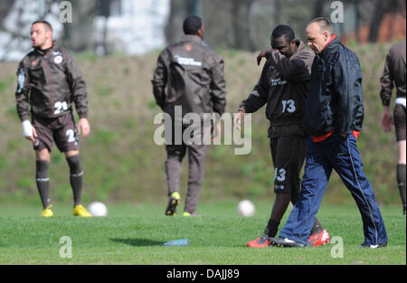Coach Holger Stanislawski (R) spricht Stürmer Gerald Asamoah im Trainingsgelände in Hamburg, Germany, 13. April 2011. Er wird die Fußball-Bundesligisten FC St. Pauli am Ende der Saison verlassen. FOTO: ANGELIKA WARMUTH Stockfoto