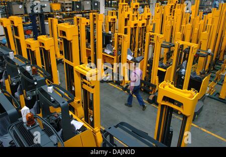 (Dpa Datei) - eine Archiv Bild, datiert 14. April 2004, zeigt ein Mitglied des Personals des Gabelstapler-Hersteller Jungheinrich AG zu Fuß Reihen von Gabelstaplern im Montagewerk in Hamburg, Deutschland passieren. Foto: Ulrich Perrey Stockfoto