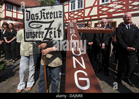 Christen besuchen die Karfreitags-Prozession mit einem Fwooden Kreuz in Lohr am Main, Deutschland, 22. April 2011. Die Prozession findet eines von nur drei vollständig sein Bild Prozessionen zu Ostern in Deutschland erhalten. Die Prozession beginnt mit einem Bild von das letzte Abendessen und endet mit einem Bild der Grablegung Christi. Foto: Daniel Karmann Stockfoto