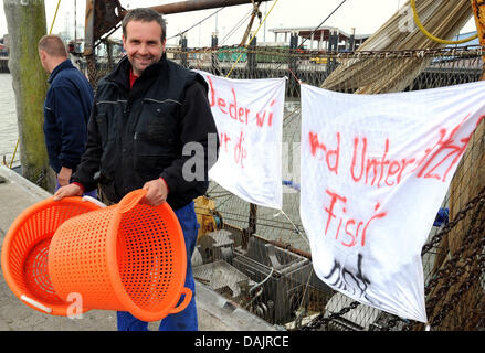 Fischer-Protest mit leeren Körben und Banner gegen die Preisgestaltung der Nordseekrabben in den Hafen von Norddeich, Deutschland, 27. April 2011. Die Fischer an der unteren sächsischen Küste planen einen vierwöchigen Streik als Protest gegen die deutschen und europäischen Fischereipolitik, die um zu trostlos Krabbenfischerei in Deutschland geführt. Foto: Ingo Wagner Stockfoto